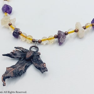 May include: A necklace with a copper leaf pendant and a mix of amethyst, citrine, and clear quartz beads.