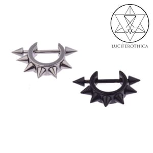 以下が含まれることがあります： 中央にバーが付いた、銀と黒のスパイク付き円形ボディジュエリー2個。ジュエリーは、ピアスとして着用するように設計されています。