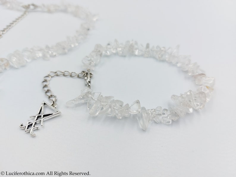 Puede incluir: Un collar de cadena de plata con un colgante de plata con un dise&ntilde;o geom&eacute;trico. El collar est&aacute; hecho con virutas de cuarzo transparente.