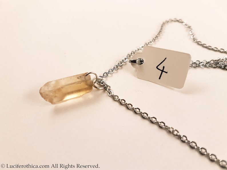 May include: A silver chain necklace with a clear quartz crystal pendant. The necklace has a tag with the number "4" written on it.