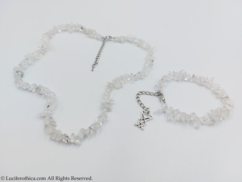 Puede incluir: Un conjunto de dos collares hechos con virutas de cuarzo transparente. El collar m&aacute;s largo tiene un extensor de cadena plateado y el collar m&aacute;s corto tiene un dije plateado con un dise&ntilde;o geom&eacute;trico.