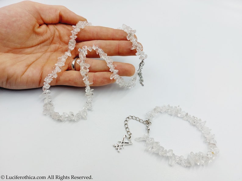 Puede incluir: Dos collares hechos de trozos de cuarzo transparente. Uno de los collares tiene una cadena de plata con un dije de pentagrama de plata.