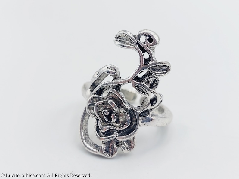 K&ouml;nnte beinhalten: Silberring mit einem detaillierten Rosen- und Rankendesign. Der Ring ist offen und hat ein zartes, filigranes Design.