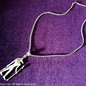 May include: Silver chain necklace with a pendant featuring an Egyptian god Anubis figure.
