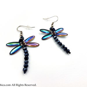 May include: A pair of iridescent dragonfly earrings with black crystal beads hanging from the bottom.