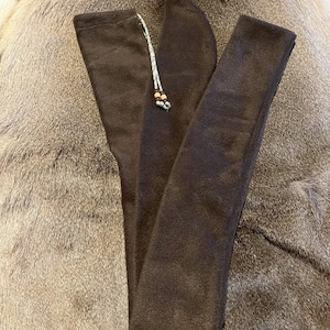 May include: A brown fleece gun sock with a drawstring closure. The sock is folded in half and lying on a furry surface.