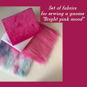 May include: A set of fabrics for sewing a gnome labeled "Bright pink mood" featuring a folded bright pink plush square, a white fabric piece, a section of long bright pink faux fur, and a piece of multi-colored faux fur with pink and blue tones.