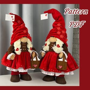 Può includere: Due gnomi di San Valentino con cappelli e vestiti di velluto rosso. Ogni gnomo ha una barba bianca, un cappotto marrone e una piccola borsa con un cuore. Tengono in mano una carta con un cuore. Il testo "Pattern PDF" è in alto a destra.