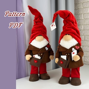 May include: Two plush gnome figures with red hats, white beards, and brown jackets. Each gnome holds a small white card and has a brown satchel with a red heart. The text "Pattern PDF" is in the upper left corner.