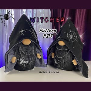 May include: Two black gnome dolls dressed as a Witcher with a black hooded cloak, a spider web design, and silver chains. The dolls are sitting on a white surface. The text "WITCHER Pattern PDF" is written in white letters on a black background.