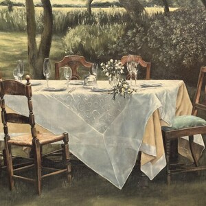 May include: An outdoor dining scene with a table set for a meal. The table is covered with a white tablecloth and set with plates, glasses, and silverware. Six wooden chairs surround the table, and a vase of flowers sits in the center.