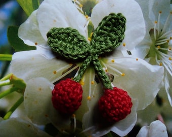 a pair of 3D crochet red cherries