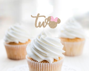 May include: Gold glitter cupcake topper with the word "two" and a pink bow on a mouse ear.