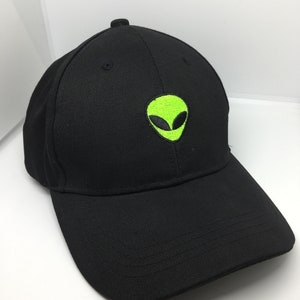 May include: Black baseball cap featuring an embroidered neon green alien head design on the front. The cap has a curved brim and a structured crown. A stylish accessory for casual wear.