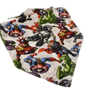 May include: A white fabric head covering featuring a colorful print of various comic book superheroes, including Captain America, Iron Man, and the Hulk. The design includes action poses and character details.