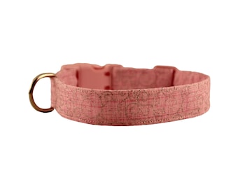May include: A pink dog collar with a gold metal buckle and a subtle pattern.