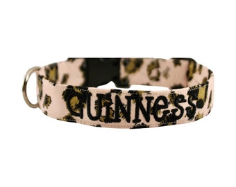 May include: Pink dog collar with a leopard print pattern and the word "GUINNESS" embroidered in black.