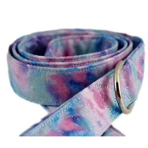 Può includere: Un guinzaglio per cani in tessuto tie-dye con un anello a D in metallo argentato. Il guinzaglio è blu, rosa e viola con una finitura glitterata bianca.