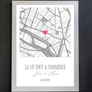 May include: A framed map print with a red heart marking a location. The text "LA OÙ TOUT A COMMENCÉ" is above the names "Jess & Lucas" and the date "28.04.2003". A black vase holds red tulips.
