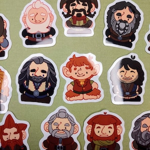 May include: A collection of cartoon stickers featuring various characters with beards, hats, and distinctive clothing. The stickers have a white border and are arranged on a light green background. The characters have different skin tones and facial expressions.