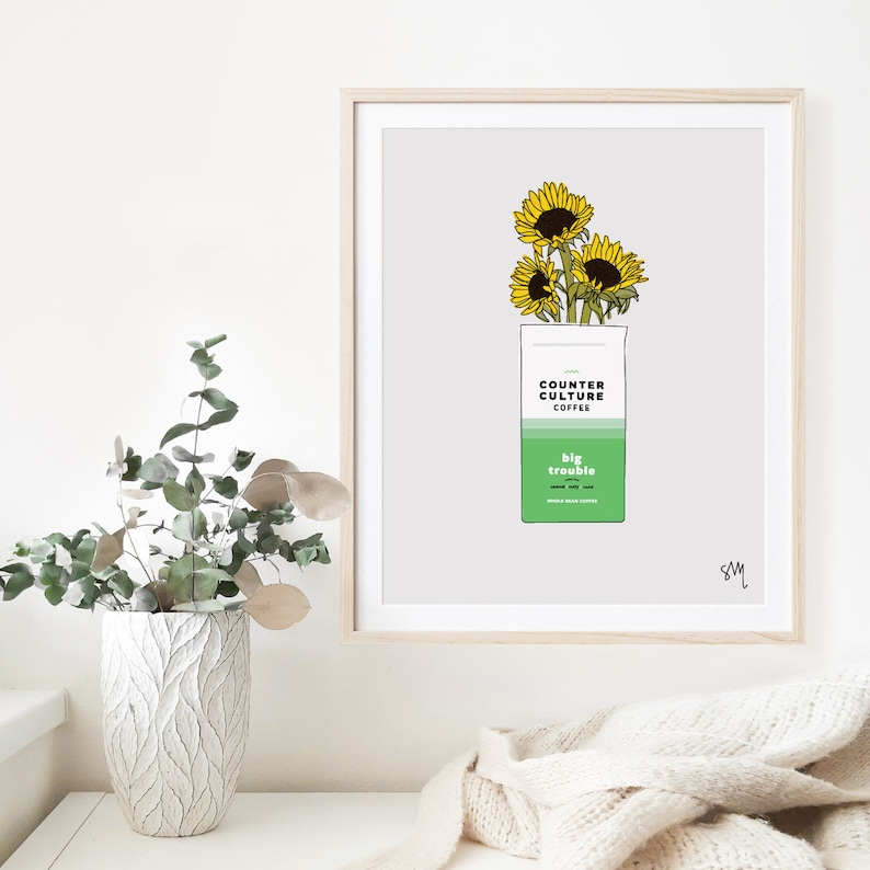 May include: A digital illustration of a coffee bag with sunflowers on top. The bag is green and white and says "Counter Culture Coffee" and "Big Trouble" on it.