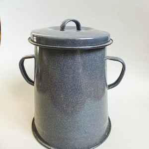 Può includere: Un contenitore in smalto grigio con coperchio e due maniglie laterali. Il contenitore ha una finitura macchiettata e una base arrotondata. Il coperchio ha una piccola maniglia sulla parte superiore. Per cucina o campeggio.