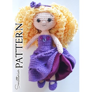 Puede incluir: Una muñeca de crochet con el pelo largo y rizado rubio, que lleva un vestido morado con un corpiño adornado con joyas y una falda de satén morado. La muñeca lleva zapatos morados.