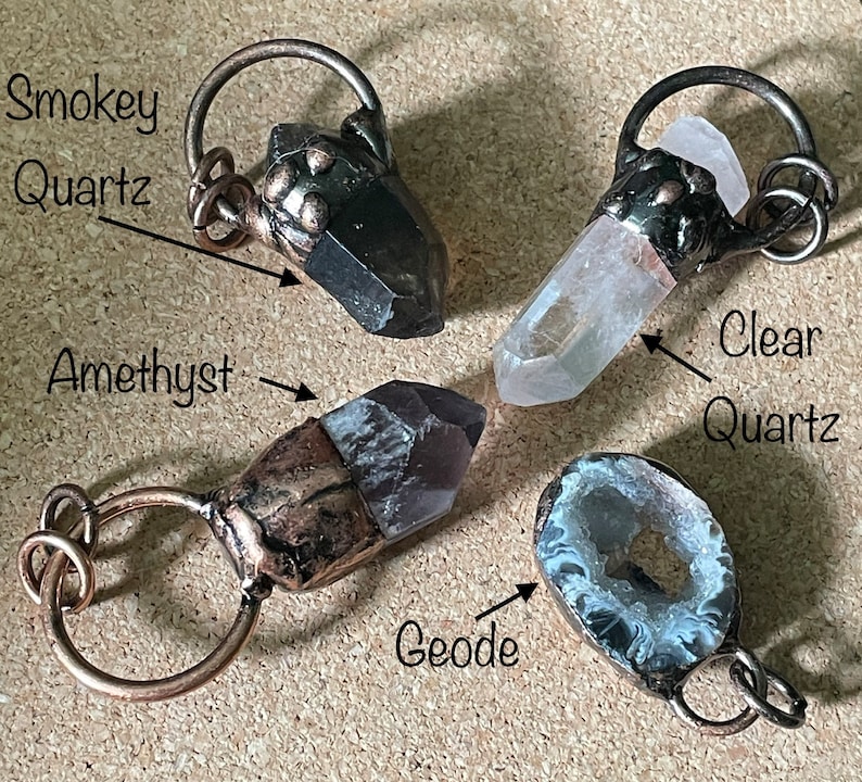Pode incluir: Quatro pingentes de cristal com la&ccedil;os de arame de cobre. Os cristais s&atilde;o quartzo fumado, quartzo transparente, ametista e uma geoda.