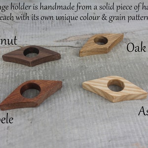 May include: Four wooden page holders in different wood types: walnut, oak, ash, and sapele. Each holder is shaped like a diamond with a hole in the center.