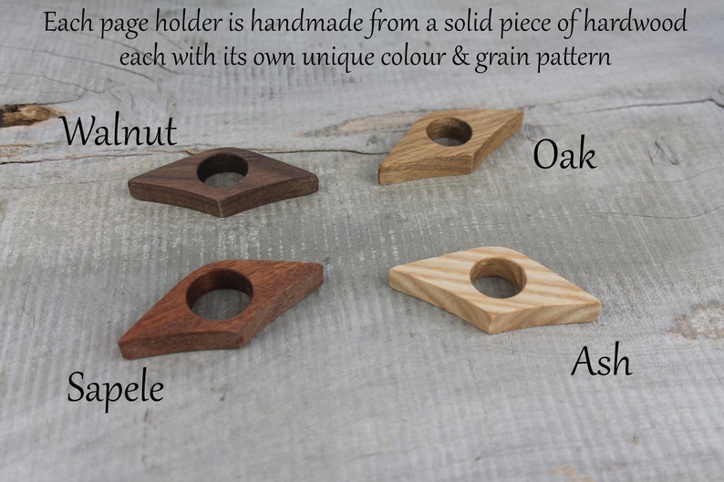 May include: Four wooden page holders in different wood types: walnut, oak, ash, and sapele. Each holder is shaped like a diamond with a hole in the center.