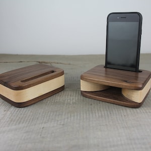 Puede incluir: Dos soportes de tel&eacute;fono de madera, uno con un tel&eacute;fono. Los soportes est&aacute;n hechos de madera de nogal y arce y tienen un dise&ntilde;o curvo para amplificar el sonido.