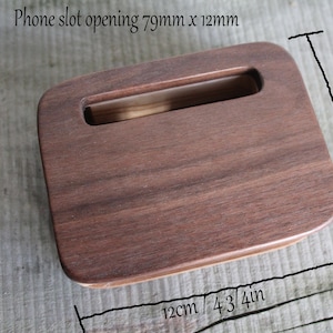 Puede incluir: Un soporte de tel&eacute;fono de madera con una abertura de ranura que mide 79 mm x 12 mm. El soporte mide 9 cm (3 1/2 pulgadas) de alto y 12 cm (4 3/4 pulgadas) de ancho.