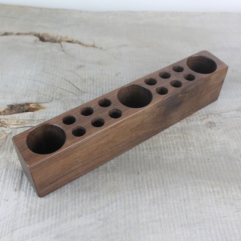 May include: A wooden organizer with multiple compartments of varying sizes. The organizer is made of dark brown wood and has a rectangular shape.