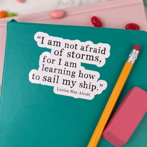 May include: A white sticker with a quote by Louisa May Alcott: "I am not afraid of storms, for I am learning how to sail my ship."