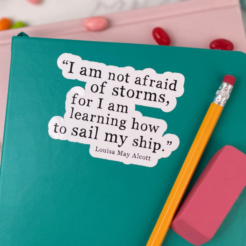 May include: A white sticker with a quote by Louisa May Alcott: "I am not afraid of storms, for I am learning how to sail my ship."