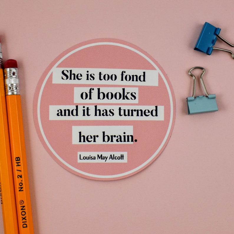 Puede incluir: Una pegatina redonda rosa con una cita de Louisa May Alcott que dice: "Ella es demasiado aficionada a los libros y eso le ha vuelto el cerebro."
