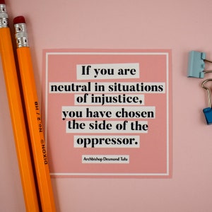 May include: A pink card with a quote by Archbishop Desmond Tutu: "If you are neutral in situations of injustice, you have chosen the side of the oppressor."