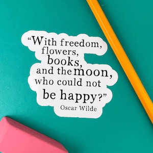May include: A white sticker with a black quote by Oscar Wilde: "With freedom, flowers, books, and the moon, who could not be happy?"