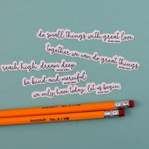 May include: Four white stickers with inspirational quotes by Mother Teresa on a light blue background. The quotes are: "do small things with great love", "together we can do great things", "reach high... dream deep", and "be kind and merciful. We only have today. Let us begin."