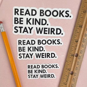 May include: Three white stickers with black text that reads "Read Books. Be Kind. Stay Weird."