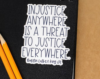 May include: A white sticker with black text that reads "Injustice anywhere is a threat to justice everywhere. Martin Luther King Jr."