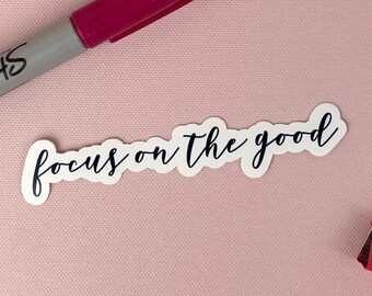 May include: White sticker with the text "focus on the good" written in black cursive script.