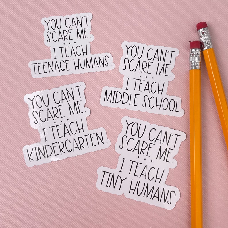May include: Four white stickers with black text on a pink background. The stickers say "You can't scare me. I teach..." followed by "teenage humans", "middle school", "kindergarten", and "tiny humans".