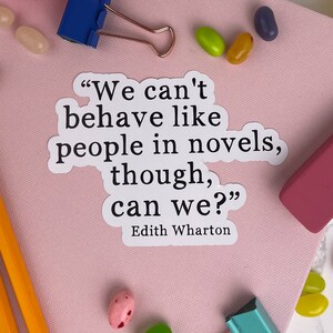 May include: A white sticker with a quote by Edith Wharton: "We can't behave like people in novels, though, can we?" The sticker is on a pink surface with jelly beans scattered around it.