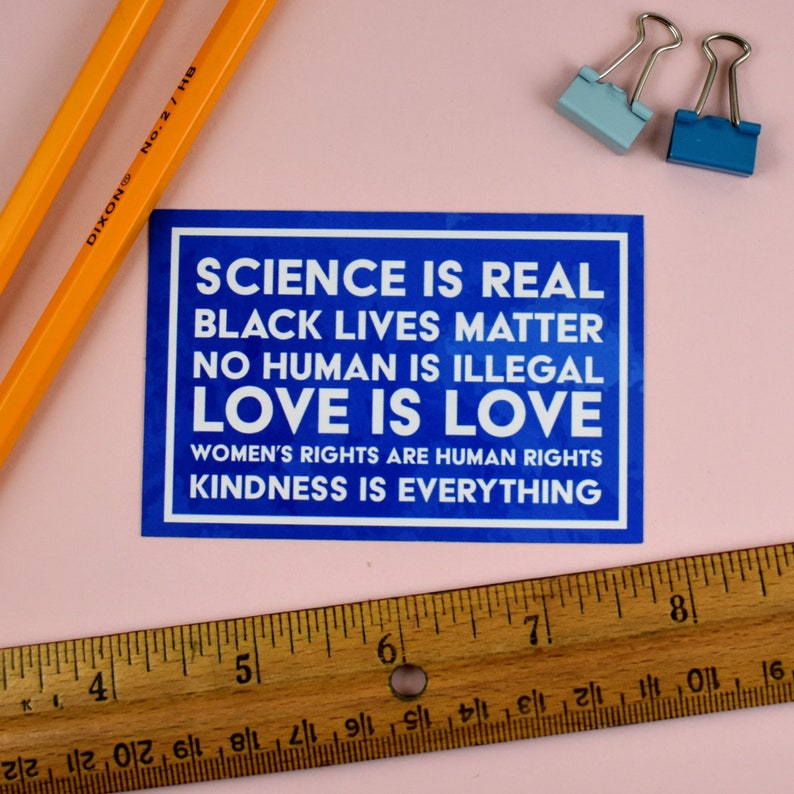 May include: A blue square sticker with white text that reads "Science is real, Black Lives Matter, No Human is Illegal, Love is Love, Women's Rights are Human Rights, Kindness is Everything."