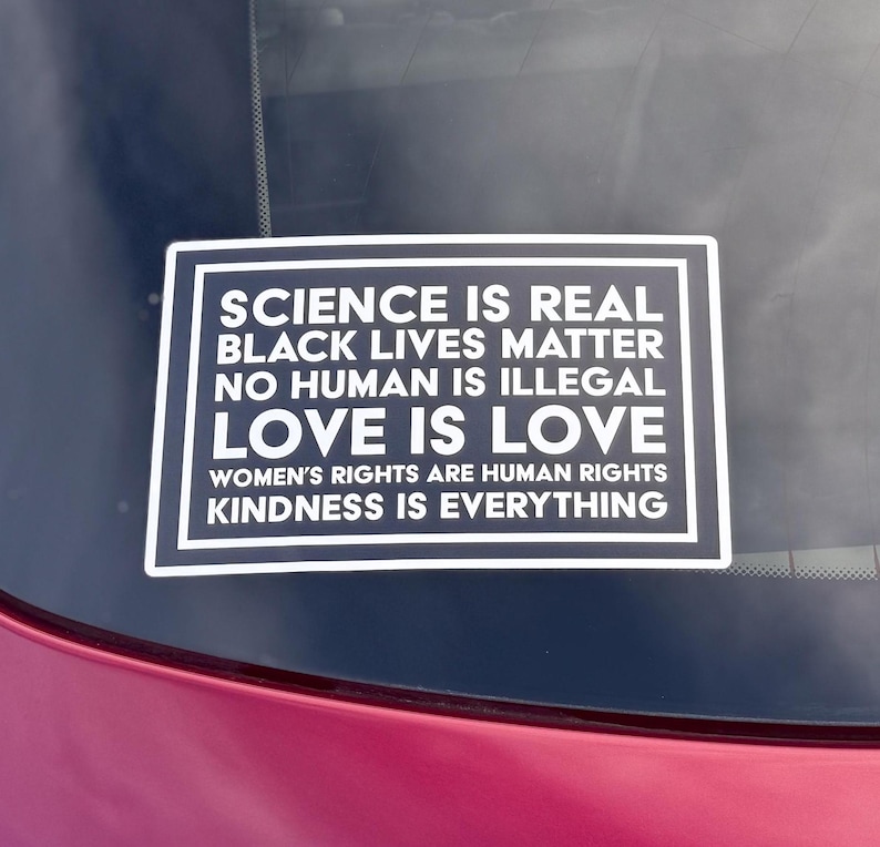May include: A black and white sticker with the text "SCIENCE IS REAL, BLACK LIVES MATTER, NO HUMAN IS ILLEGAL, LOVE IS LOVE, WOMEN'S RIGHTS ARE HUMAN RIGHTS, KINDNESS IS EVERYTHING."