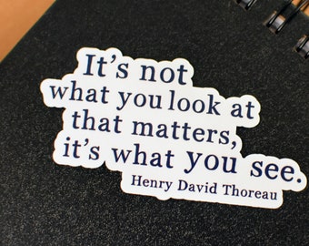 May include: A white sticker with a black quote by Henry David Thoreau: "It's not what you look at that matters, it's what you see."