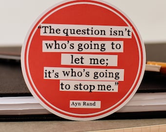 May include: A red round sticker with a white border and black text. The text reads "The question isn't who's going to let me; it's who's going to stop me."  The text is attributed to Ayn Rand.