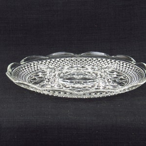 May include: A clear glass serving dish with a scalloped edge and a diamond pattern. The dish has three separate compartments.
