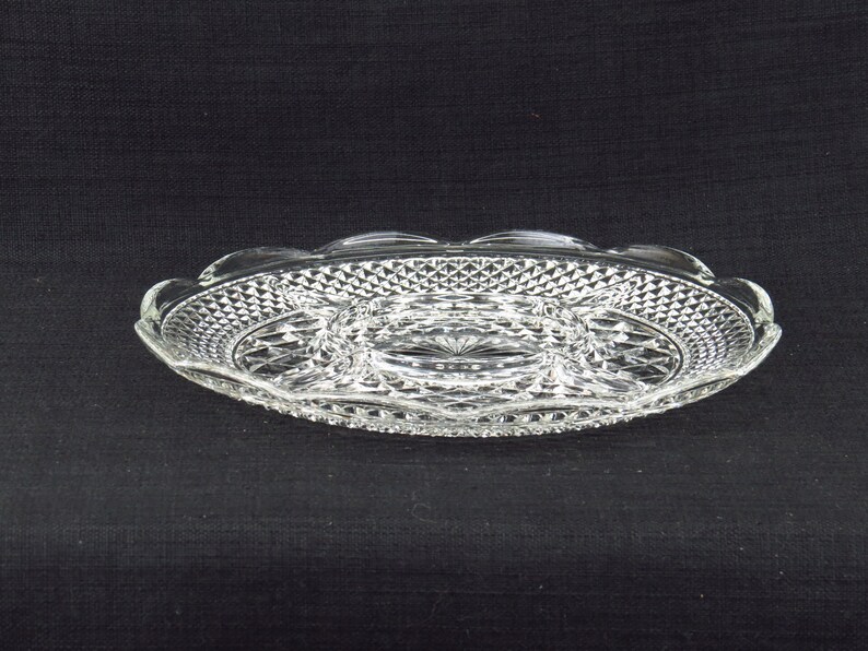 May include: A clear glass serving dish with a scalloped edge and a diamond pattern. The dish has three separate compartments.